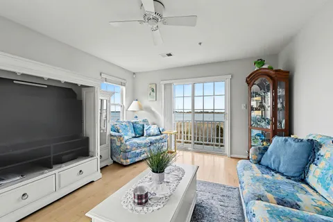 a living room with furniture chandelier and large windows