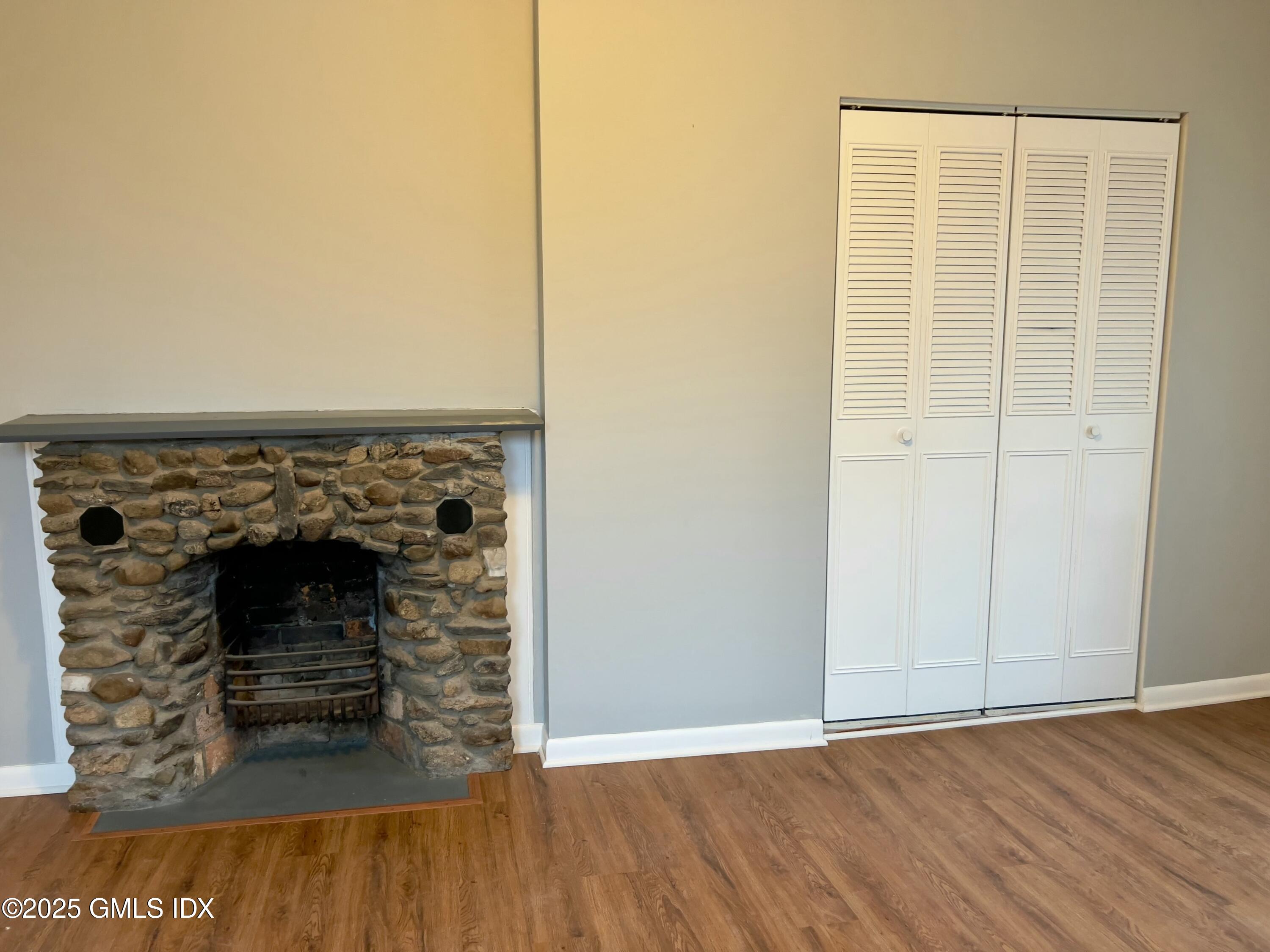300-302 Soundview Avenue, Unit 2 Fairfield, CT 06825 - Photo 13 of 20 a view of an empty room with wooden floor and a fireplace