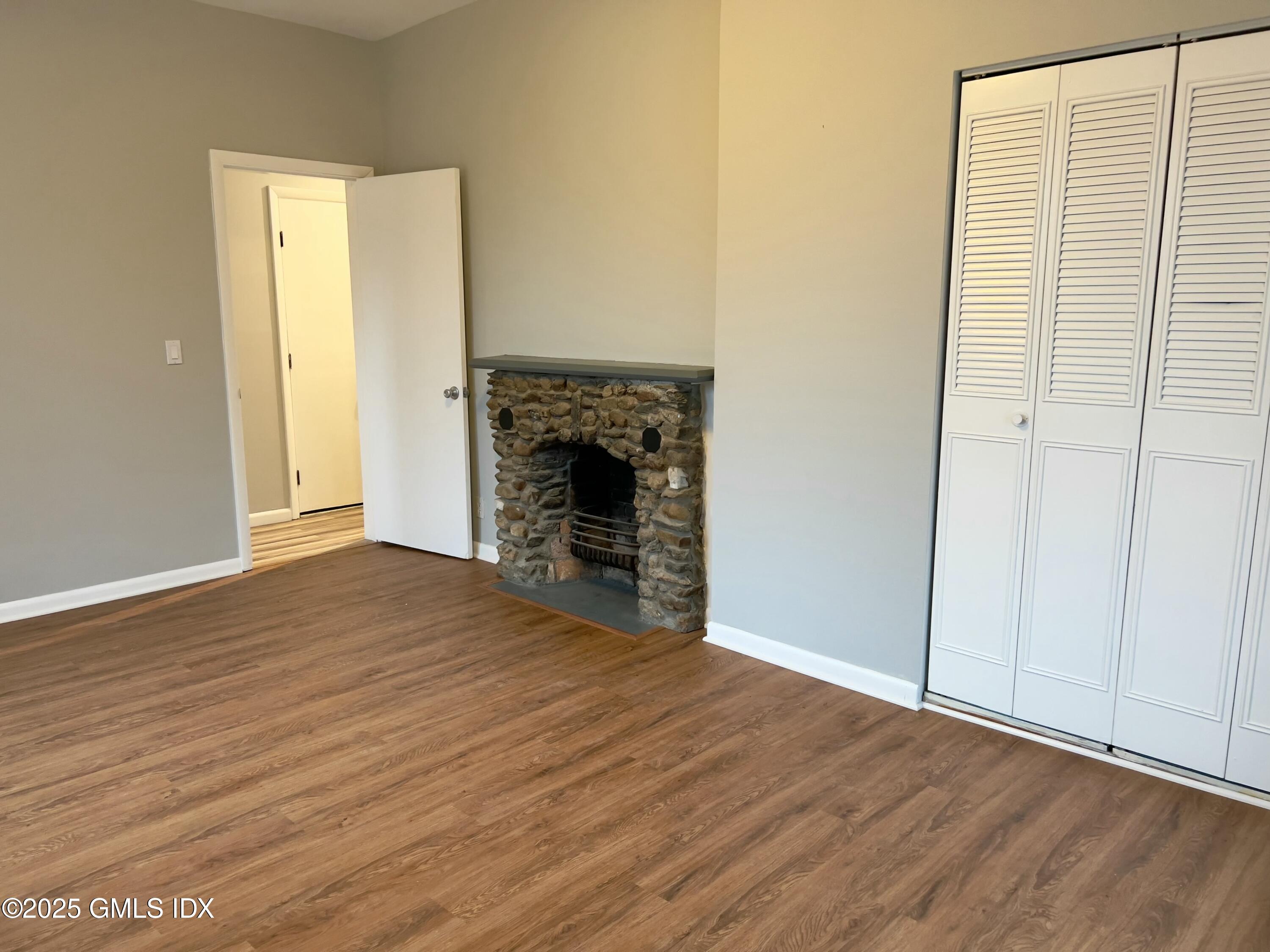 300-302 Soundview Avenue, Unit 2 Fairfield, CT 06825 - Photo 14 of 20 an empty room with wooden floor and fireplace