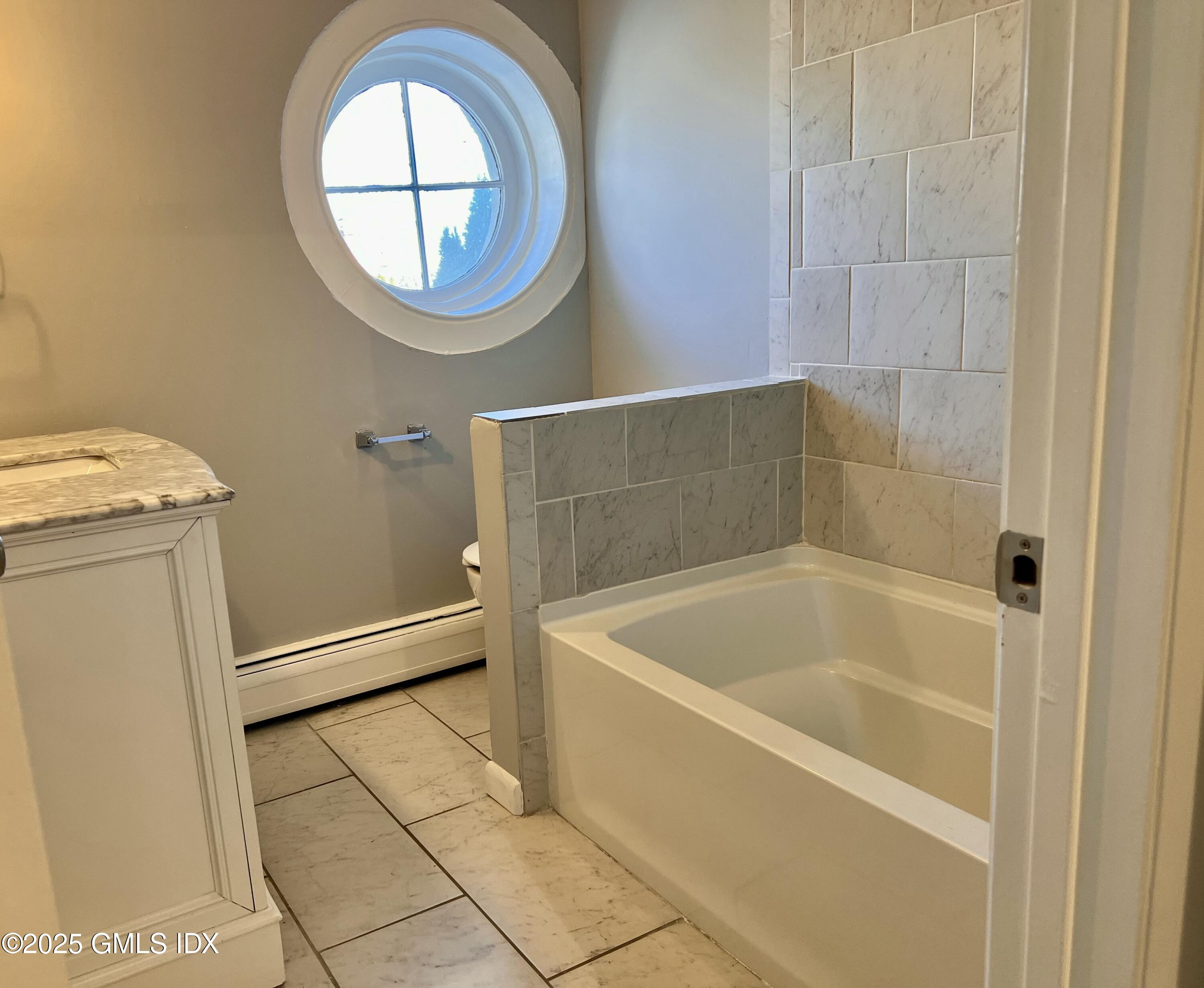 300-302 Soundview Avenue, Unit 2 Fairfield, CT 06825 - Photo 17 of 20 a bathroom with a tub and a window