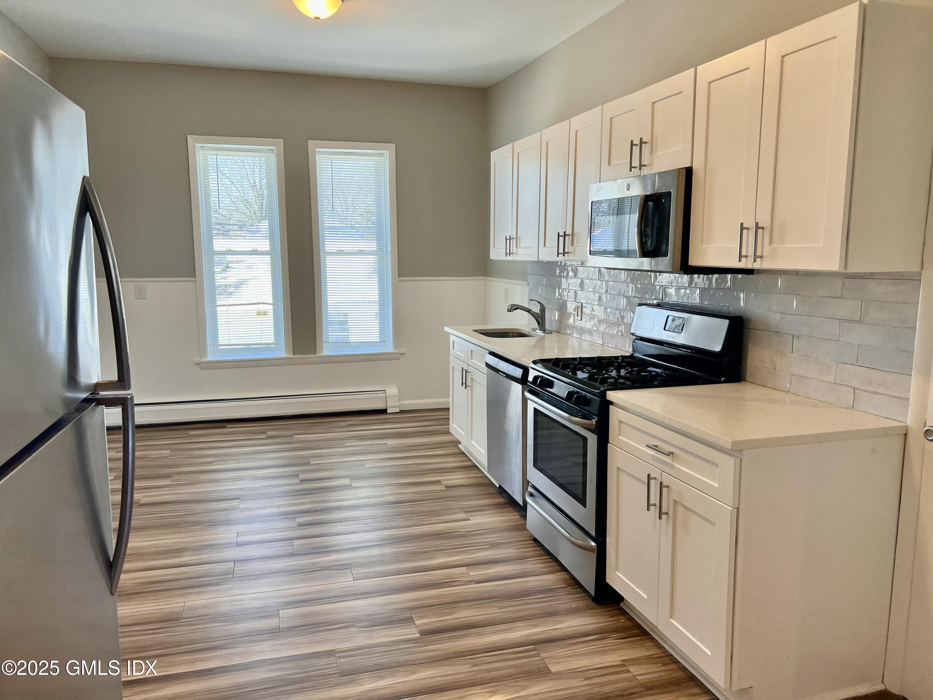 300-302 Soundview Avenue, Unit 2 Fairfield, CT 06825 - Photo 6 of 20 a kitchen with stainless steel appliances a stove microwave and sink