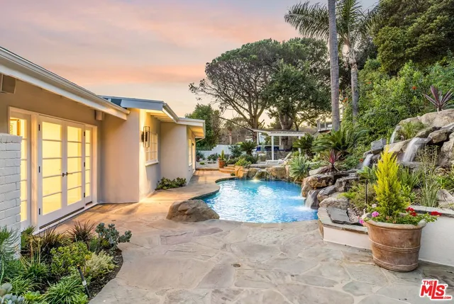 a kitchen with granite countertop kitchen island stainless steel appliances a sink a counter top space and living room view