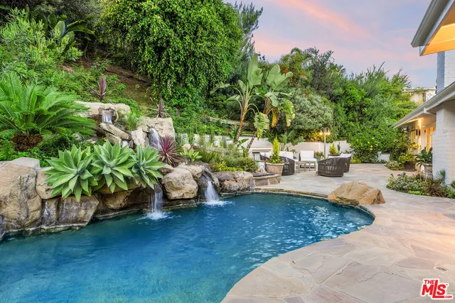 a kitchen with stainless steel appliances granite countertop a sink a stove and a refrigerator