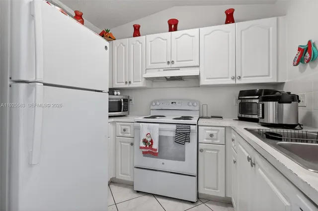 a kitchen with white cabinets and white appliances