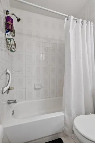 a bathroom with a shower a toilet and sink