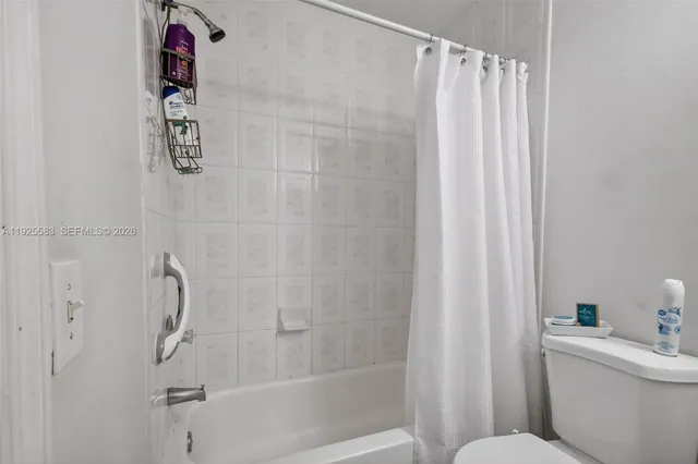 a bathroom with a shower curtain and a window