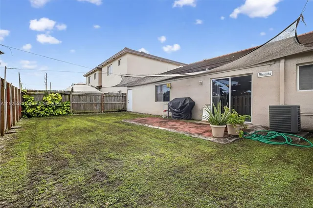 a view of a house with backyard and a garden