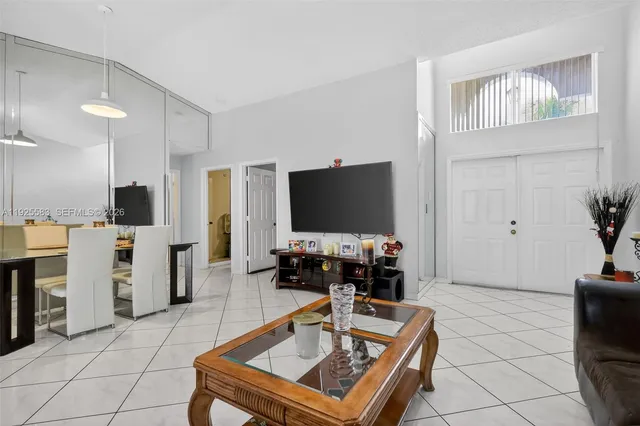 a living room with a flat screen tv and a dining table