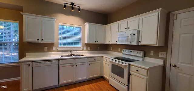 a kitchen with white cabinets and white appliances