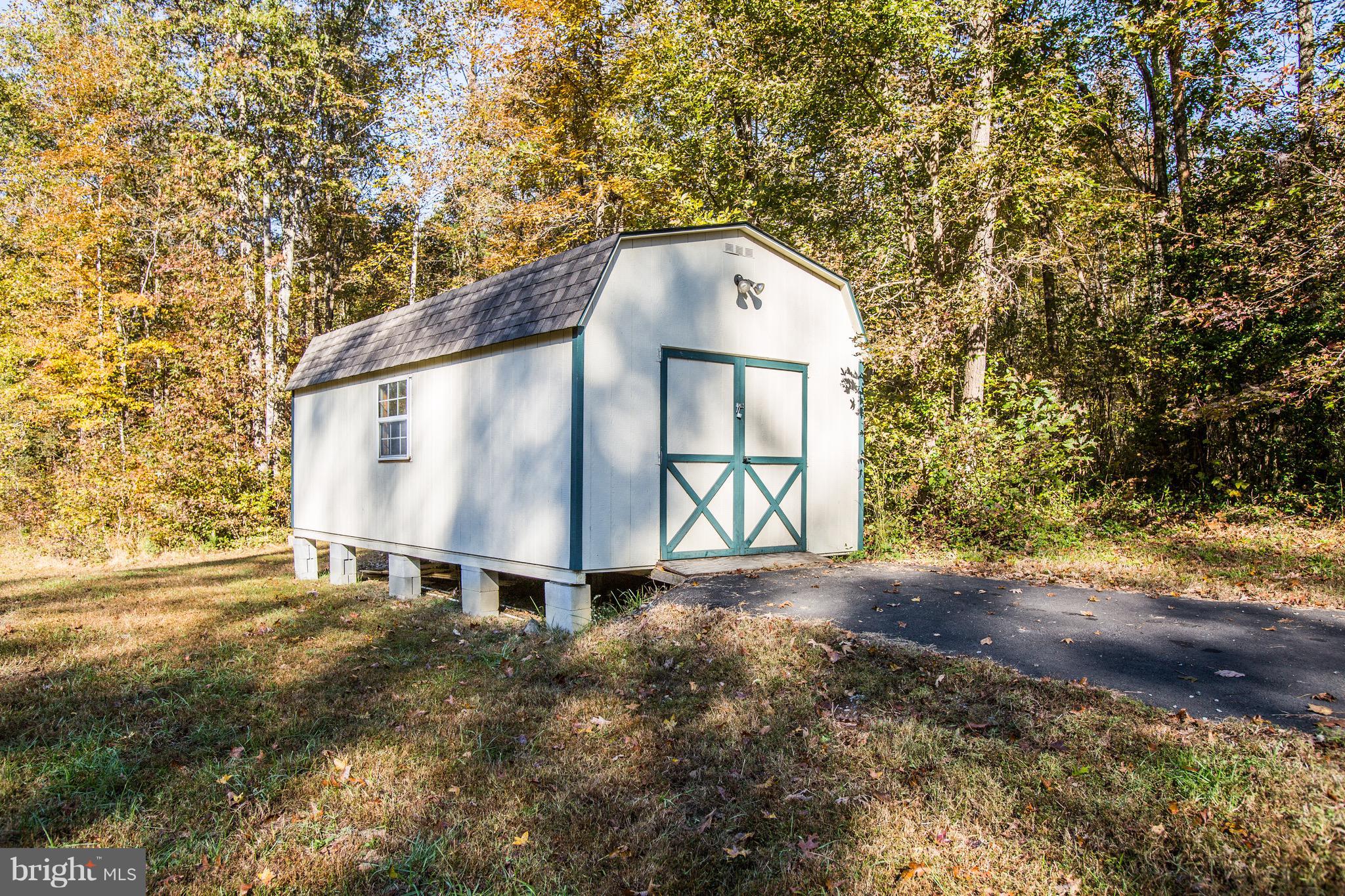 6628 Partlow Road Spotsylvania, VA 22551 - Photo 16 of 22 a backyard of a house with large trees and wooden fence