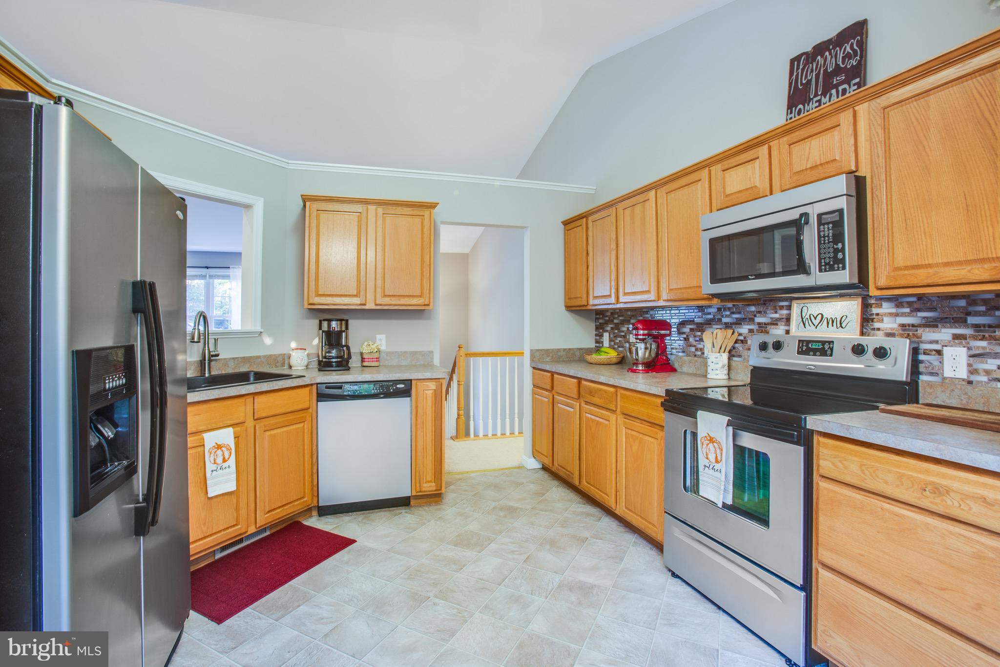 6628 Partlow Road Spotsylvania, VA 22551 - Photo 6 of 22 a kitchen with stainless steel appliances granite countertop a stove top oven a sink dishwasher a refrigerator and a microwave oven