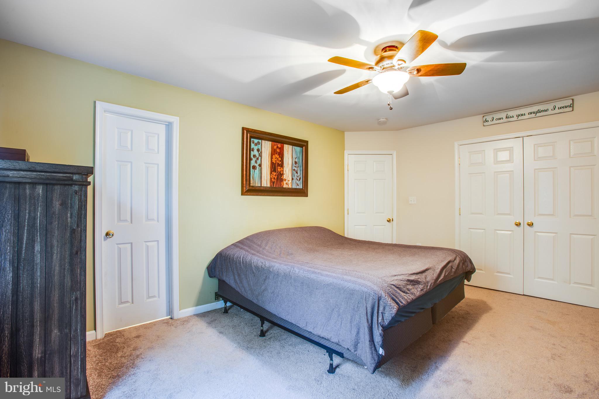 6628 Partlow Road Spotsylvania, VA 22551 - Photo 9 of 22 a spacious bedroom with a bed and a chandelier