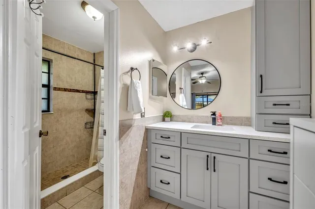a bathroom with a sink mirror and a shower