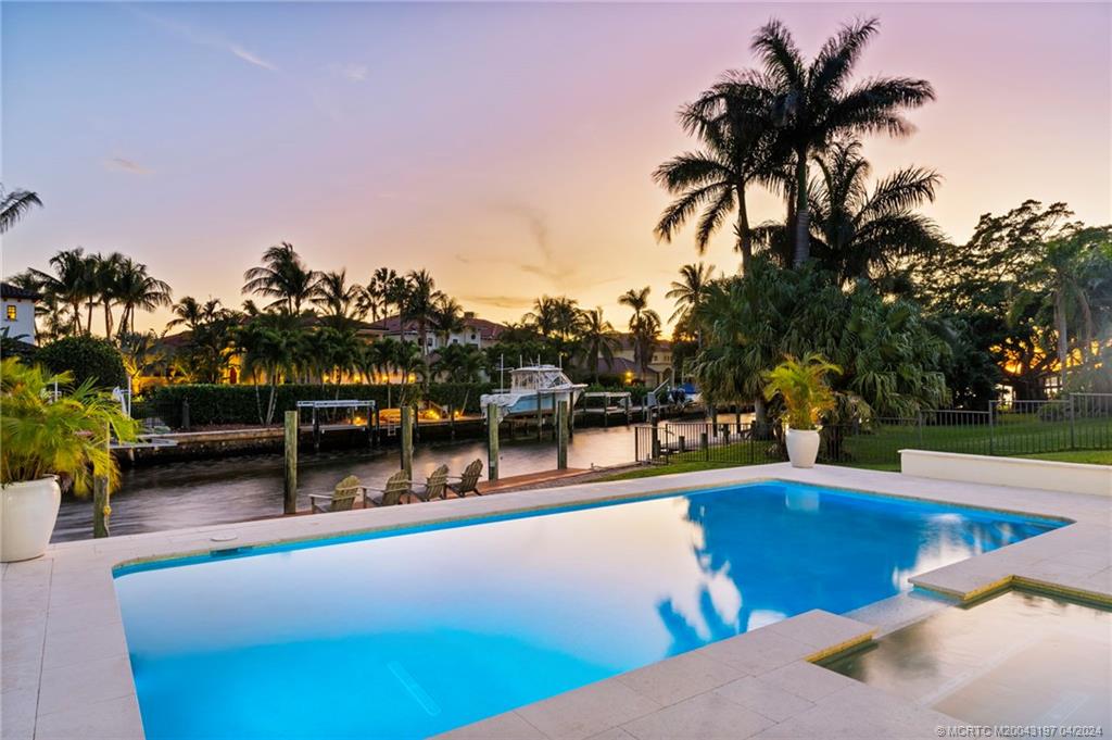 19 River Drive Jupiter, FL 33469 - Photo 18 of 46 a view of a swimming pool with a bench and trees