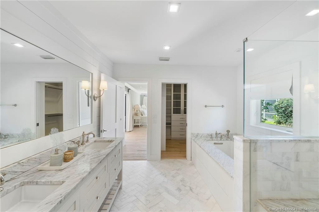 19 River Drive Jupiter, FL 33469 - Photo 23 of 46 a spacious bathroom with a granite countertop sink a mirror a bathtub and shower