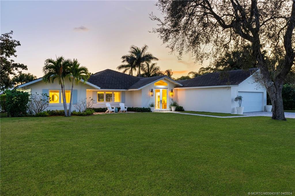 19 River Drive Jupiter, FL 33469 - Photo 25 of 46 a front view of house with yard and outdoor seating