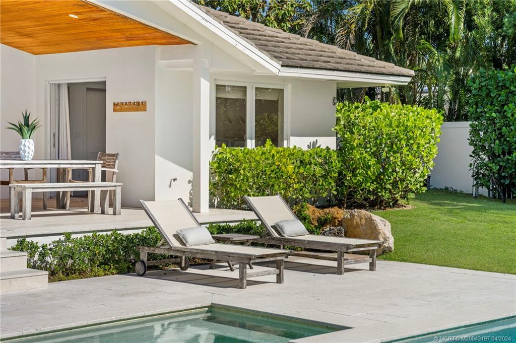 19 River Drive Jupiter, FL 33469 - Photo 32 of 46 a view of a white house with a yard and sitting area