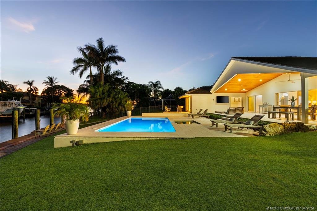 19 River Drive Jupiter, FL 33469 - Photo 42 of 46 a view of a swimming pool with lawn chairs and a yard