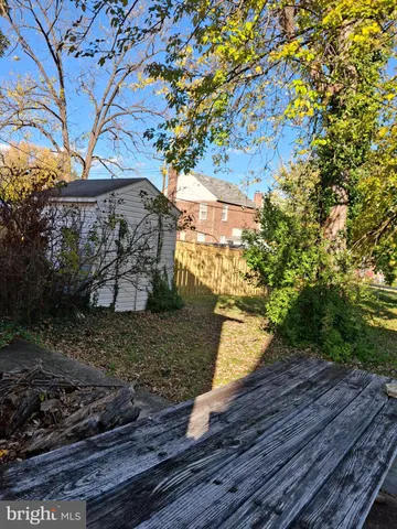 a view of a yard with plants and wooden fence