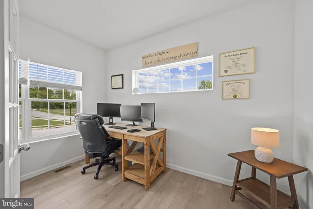 a view of a workspace with furniture and a window