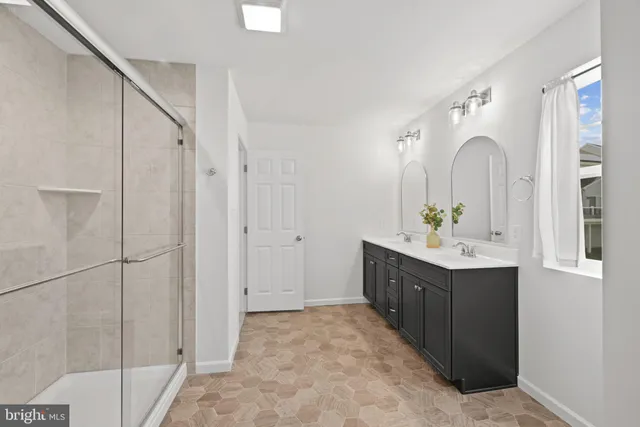 a spacious bathroom with a double vanity sink and mirror