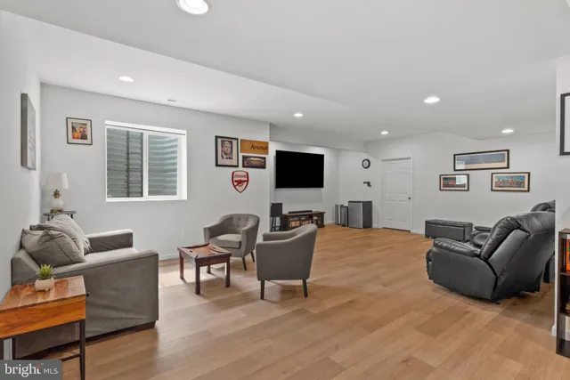 a living room with furniture a flat screen tv and wooden floor