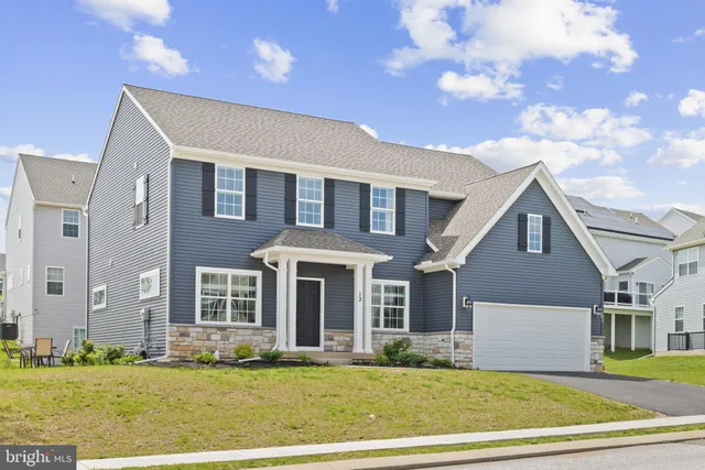 a view of a house next to a yard with big trees
