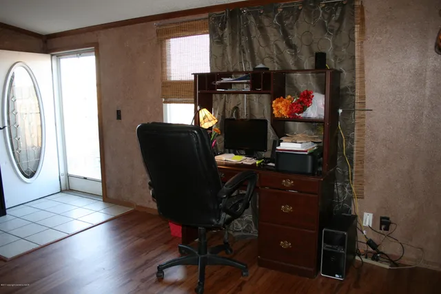 a view of a workspace with furniture and a window
