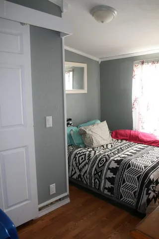 a bedroom with a bed and wooden floor