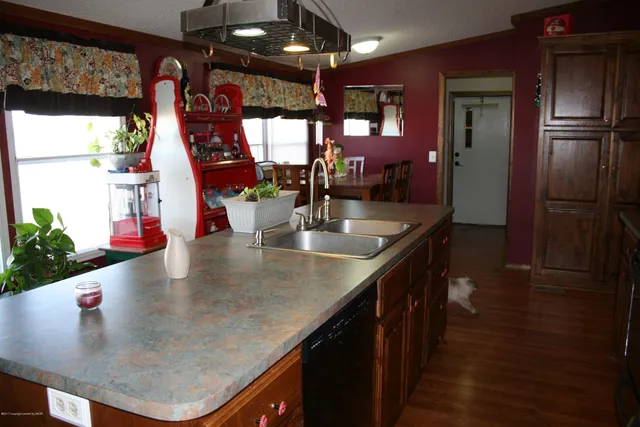 an open kitchen with a sink and refrigerator