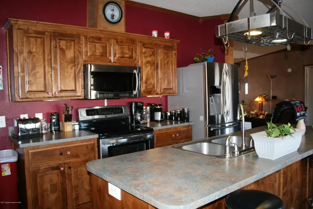 a kitchen with stainless steel appliances a dining table and chairs