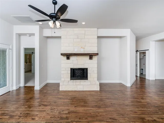 a living room with wooden floor and a fireplace