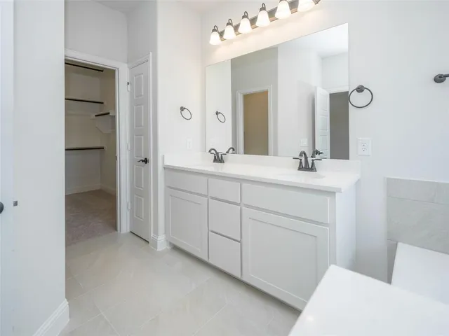 a en suite bathroom with a double vanity sink and mirror
