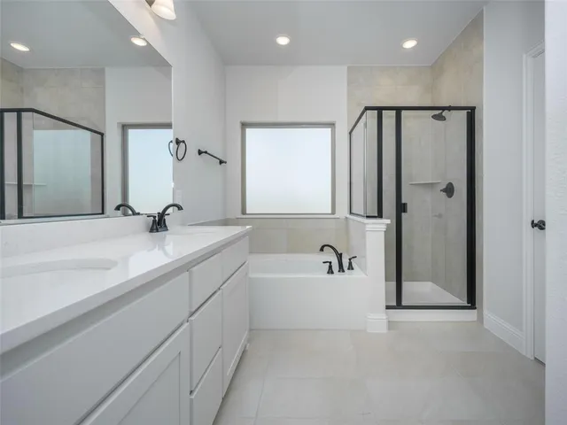 a bathroom with a bathtub shower sink and mirror