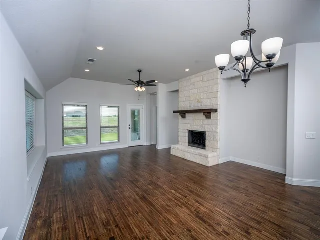 a view of a room with wooden floor fireplace and chandelier