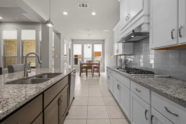 a view of kitchen with stainless steel appliances kitchen island granite countertop a refrigerator and a sink