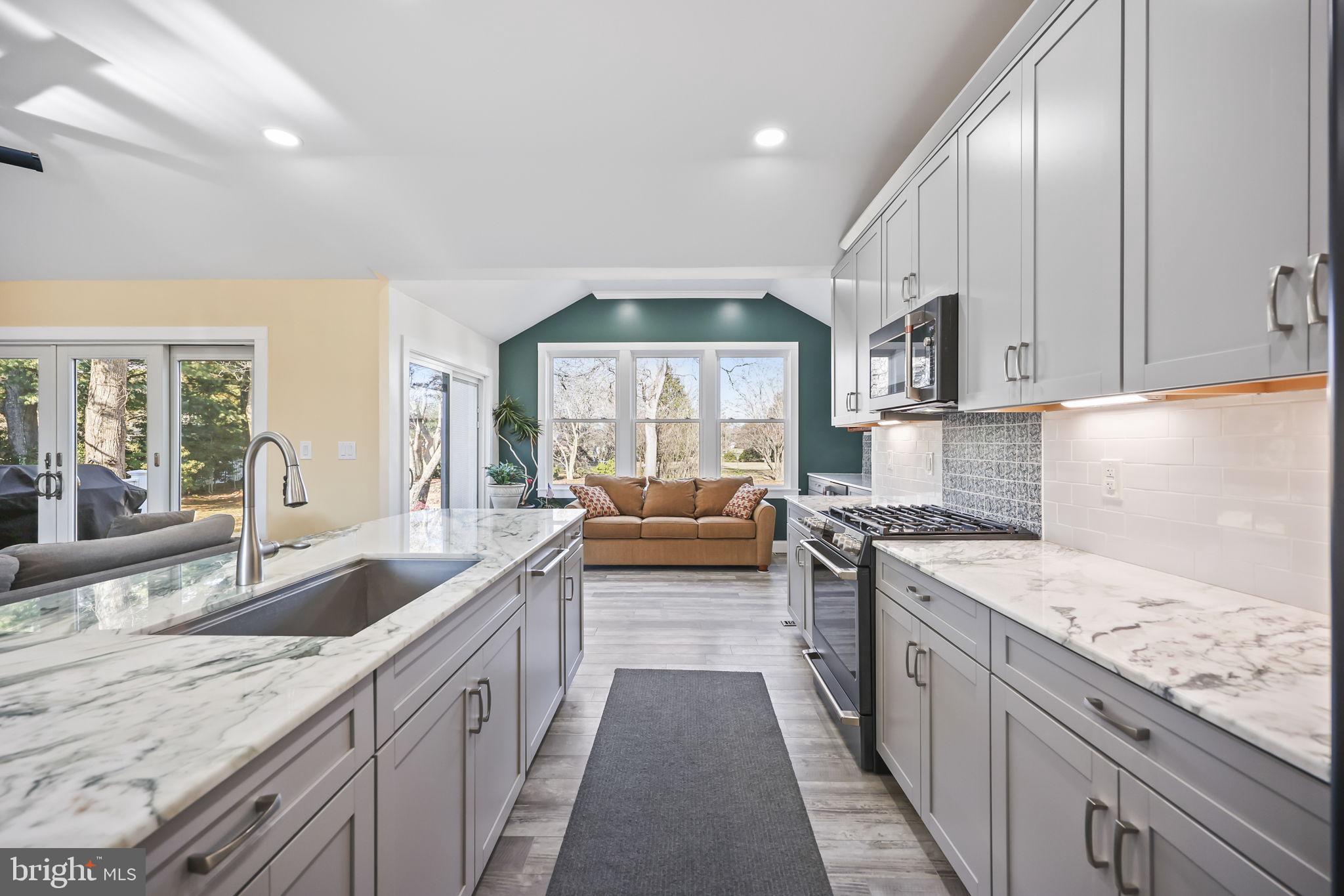 568 Village Road East Princeton Junction, NJ 08550 - Photo 11 of 43 a kitchen with granite countertop stainless steel appliances a sink stove top oven and cabinets