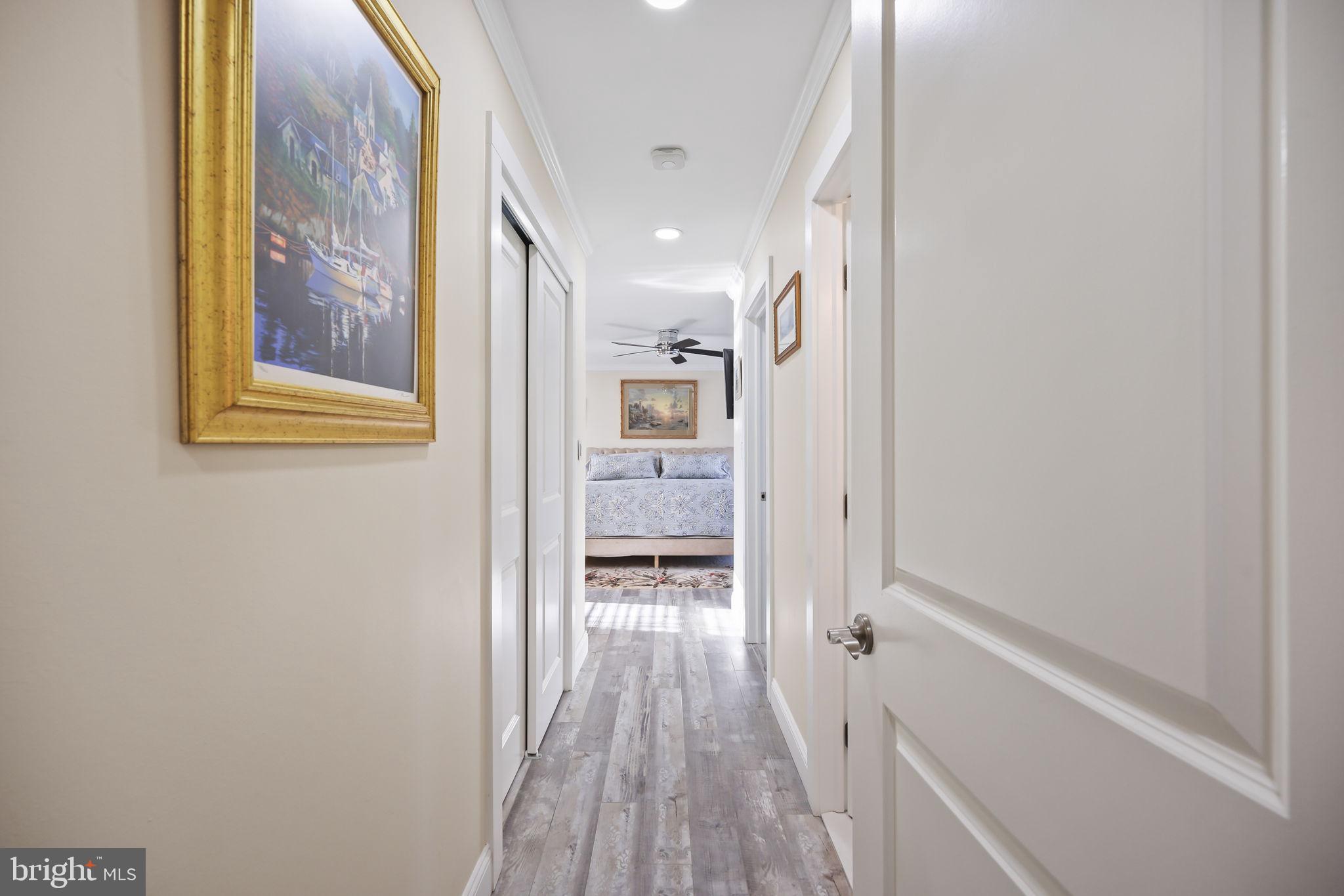568 Village Road East Princeton Junction, NJ 08550 - Photo 22 of 43 a view of a hallway with wooden floor and a bathroom