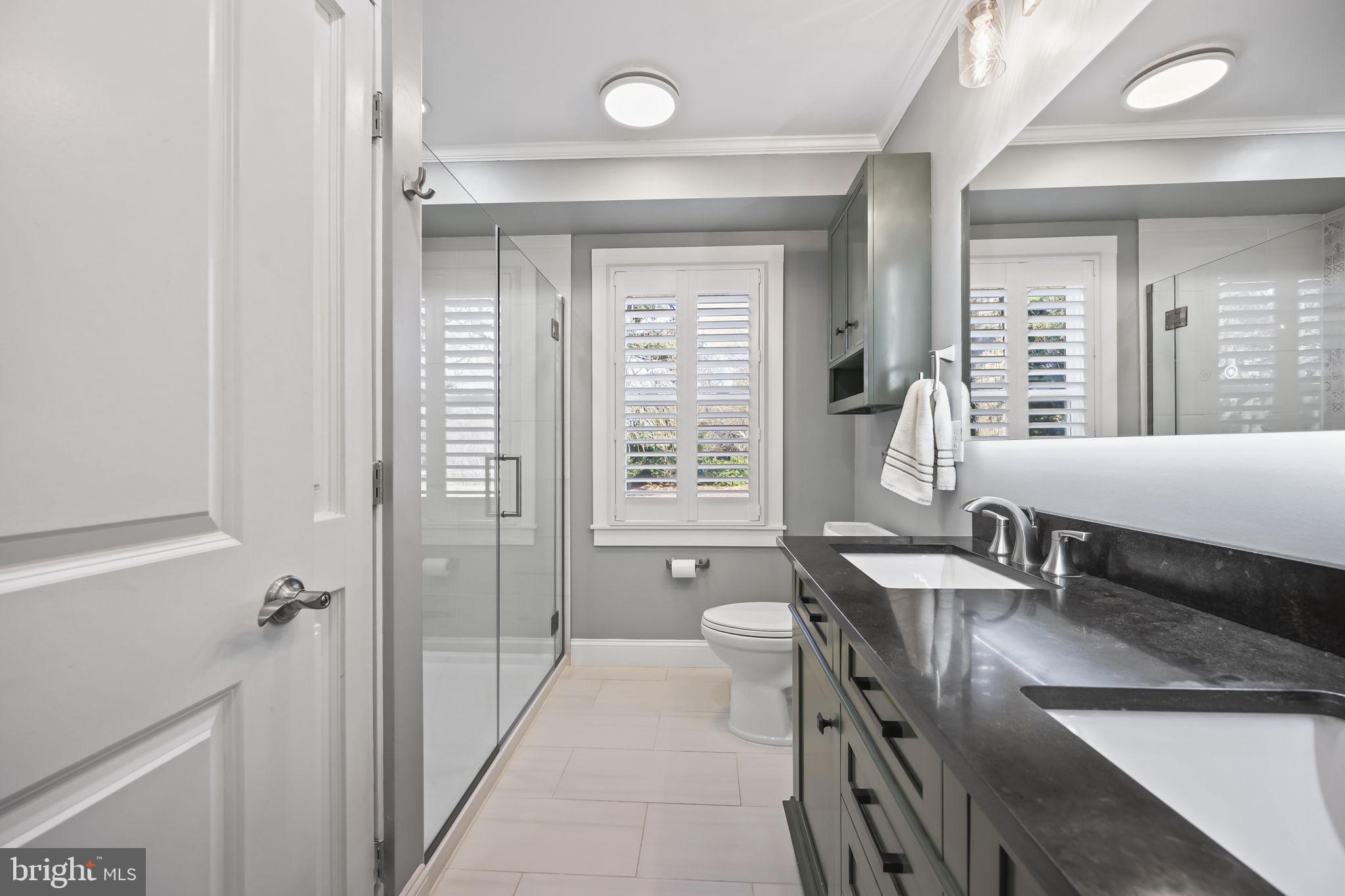 568 Village Road East Princeton Junction, NJ 08550 - Photo 27 of 43 a bathroom with a double vanity sink a mirror and a bathtub