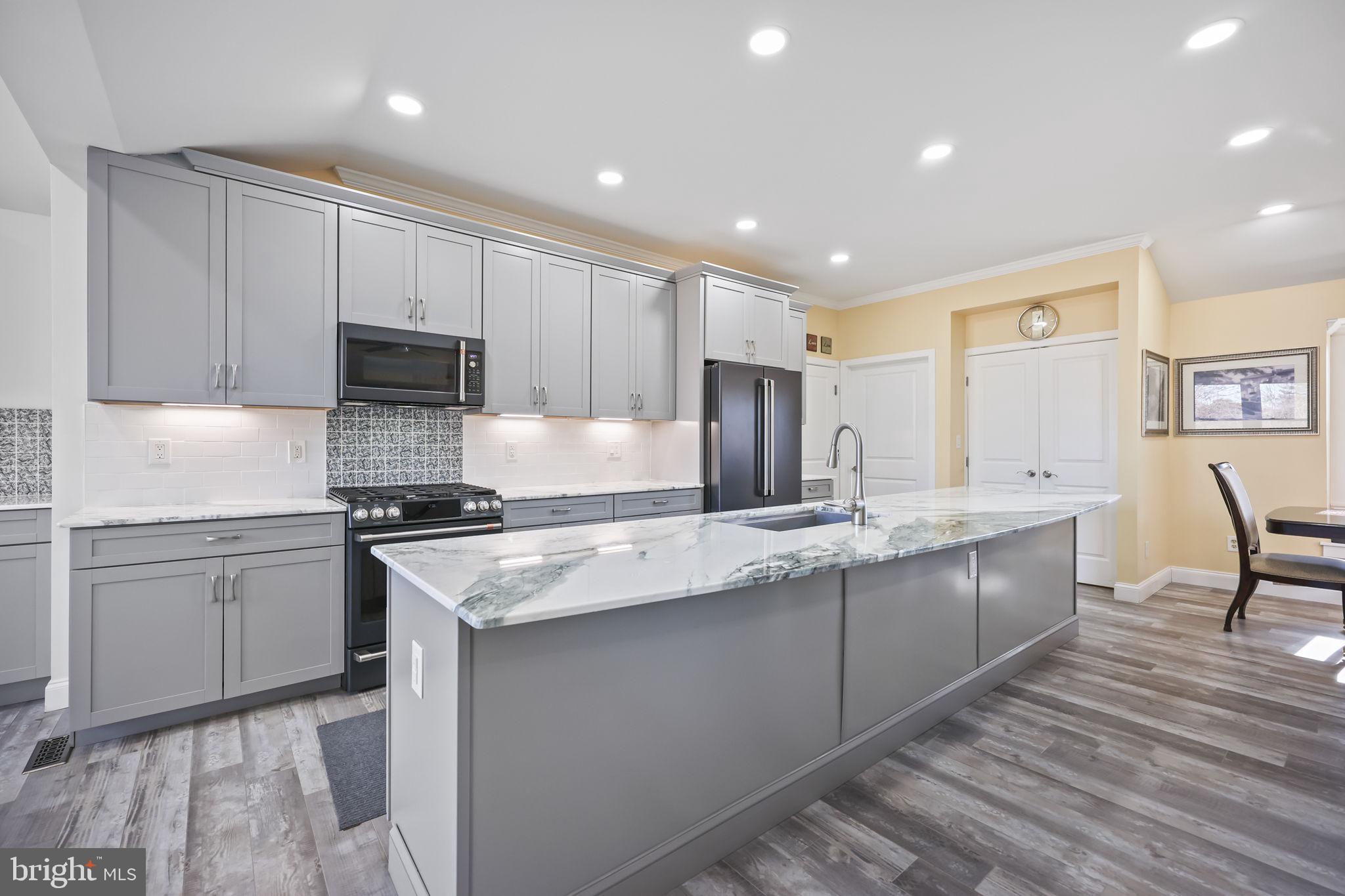 568 Village Road East Princeton Junction, NJ 08550 - Photo 7 of 43 a kitchen with stainless steel appliances granite countertop a sink stove and refrigerator