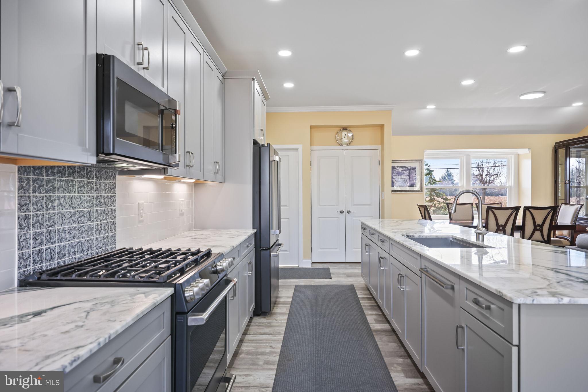 568 Village Road East Princeton Junction, NJ 08550 - Photo 9 of 43 a kitchen with stainless steel appliances granite countertop a stove a sink and a microwave