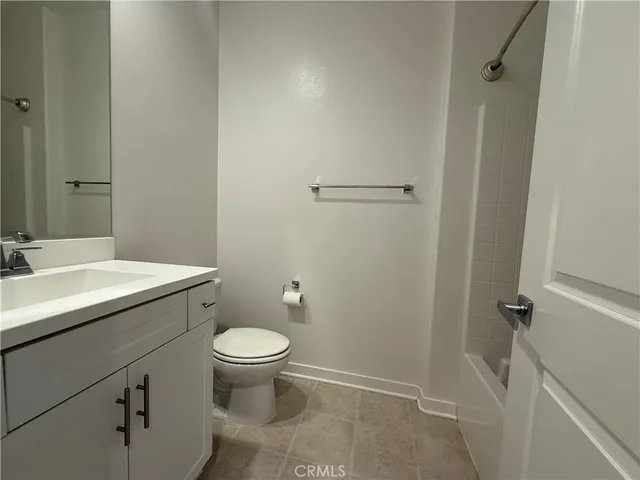 a bathroom with a granite countertop toilet a sink and a mirror