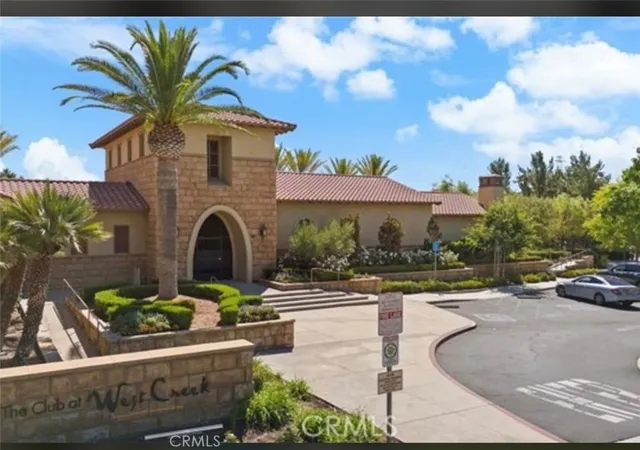a view of a house with potted plants and a fountain