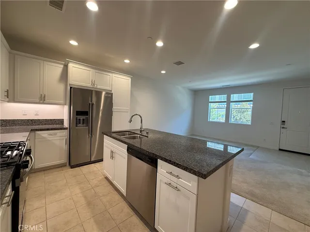 a kitchen that has a sink a refrigerator and window