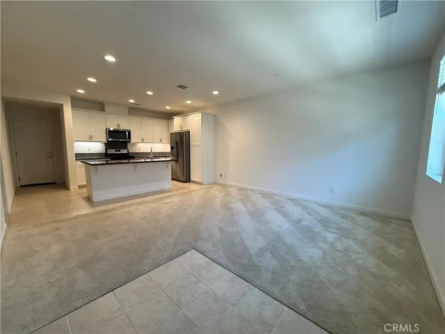a view of a kitchen with a sink and dishwasher a stove top oven with wooden floor
