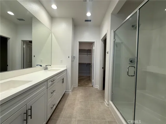 a spacious bathroom with a shower sink and mirror