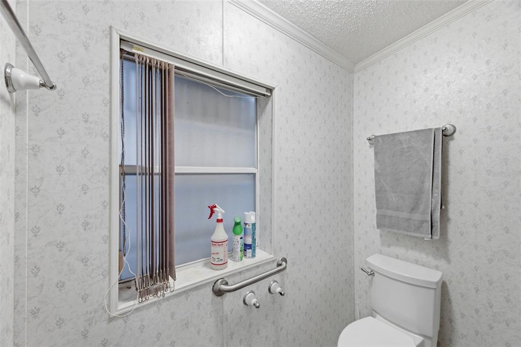 9634 Pat Street Hudson, FL 34669 - Photo 35 of 73 a bathroom with a toilet and a shower curtain