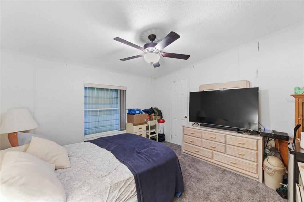 9634 Pat Street Hudson, FL 34669 - Photo 38 of 73 a bedroom with a bed and a flat screen tv