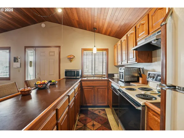 a kitchen with stainless steel appliances granite countertop a sink refrigerator and cabinets