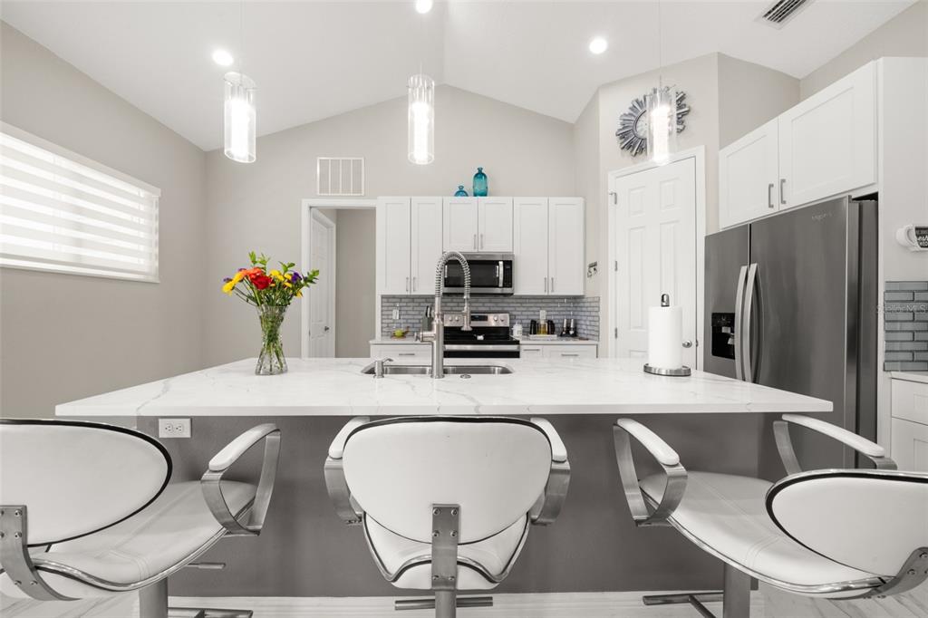 2009 Flower Terrace Sebring, FL 33875 - Photo 7 of 60 a kitchen with granite countertop a dining table chairs and a refrigerator